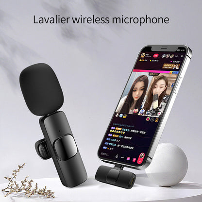 Black lavalier wireless microphone next to smartphone showing live streaming app with two women