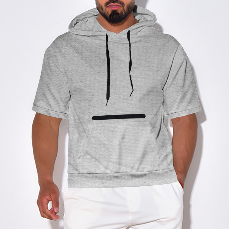Man wearing light gray short sleeve hoodie with black drawstrings and minimalist black line design, paired with white pants
