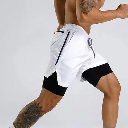 Athletic man wearing white and black running shorts with a tattoo on his leg in a dynamic pose