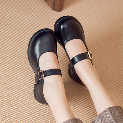 Black leather Mary Jane shoes with buckle straps worn by person on beige carpet