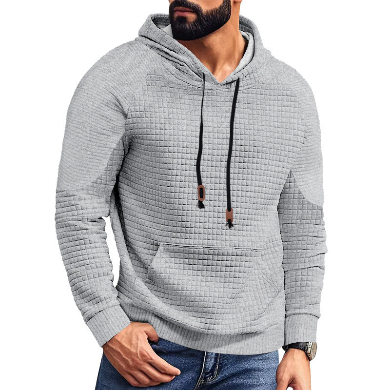 Man wearing textured light gray quilted hoodie with black drawstrings and front pocket