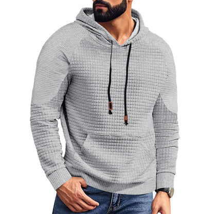 Man wearing textured light gray quilted hoodie with black drawstrings and front pocket