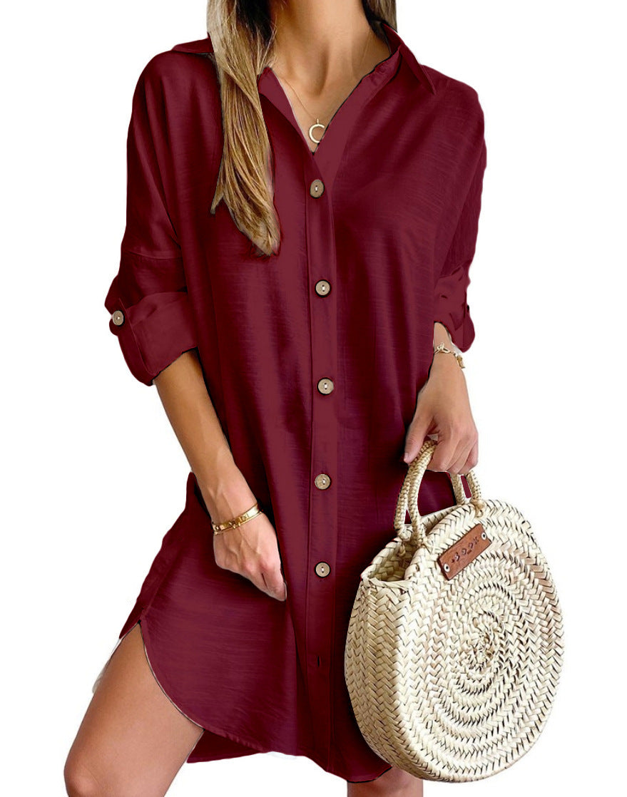 Woman wearing burgundy button-up shirt dress holding round woven straw handbag