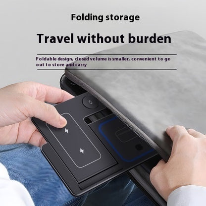 Person placing a foldable black wireless charging pad into a gray zipper pouch for convenient travel storage
