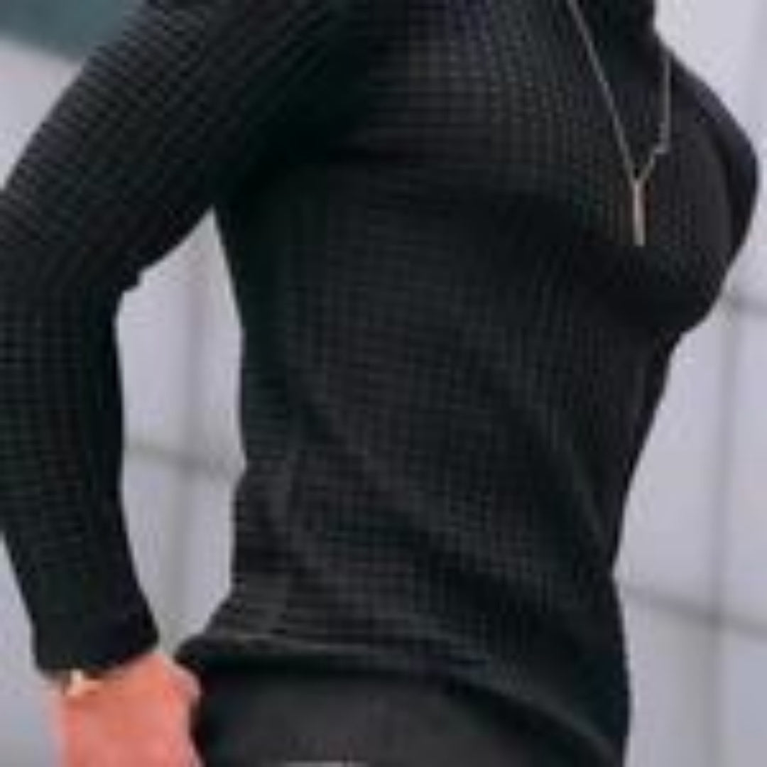 Person wearing fitted black textured long sleeve shirt with silver zipper necklace