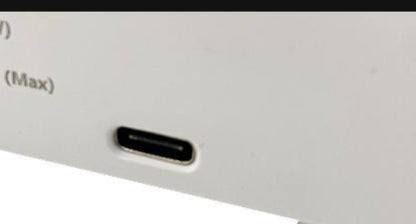 Close-up of a USB-C charging port on a white electronic device