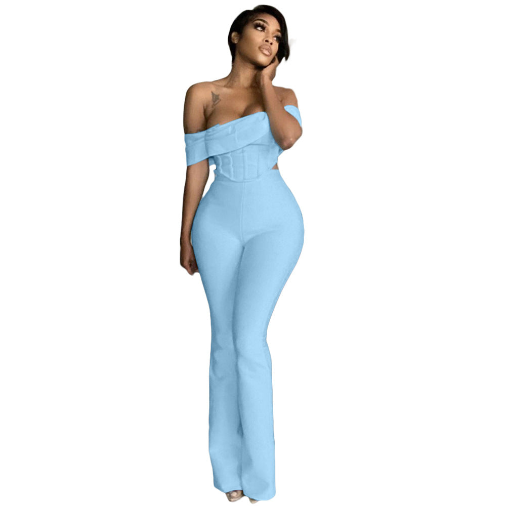 Woman wearing light blue off-shoulder fitted jumpsuit with flared pants on white background