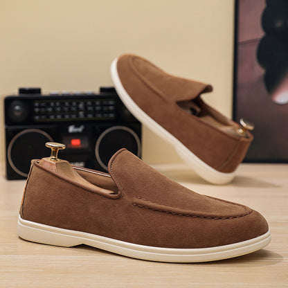 Brown suede slip-on casual men's shoes with white soles on wooden surface
