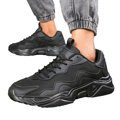 Black chunky sneakers with textured mesh and synthetic overlays worn with rolled gray jogger pants