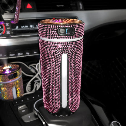 Pink rhinestone-covered portable air purifier in a car cup holder with control buttons and glowing top