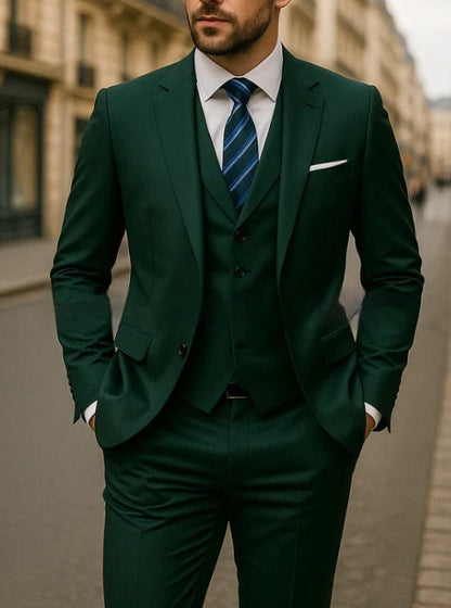 Man wearing a dark green three-piece suit with white shirt and blue striped tie on city street