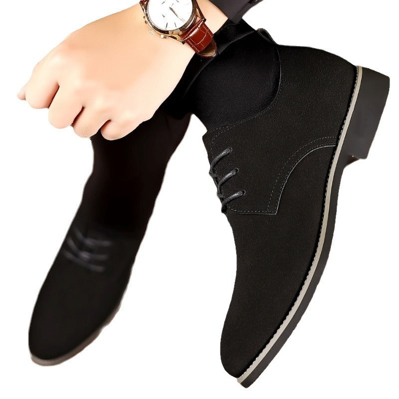 Person wearing black suede lace-up ankle boots with contrast sole and brown leather wristwatch