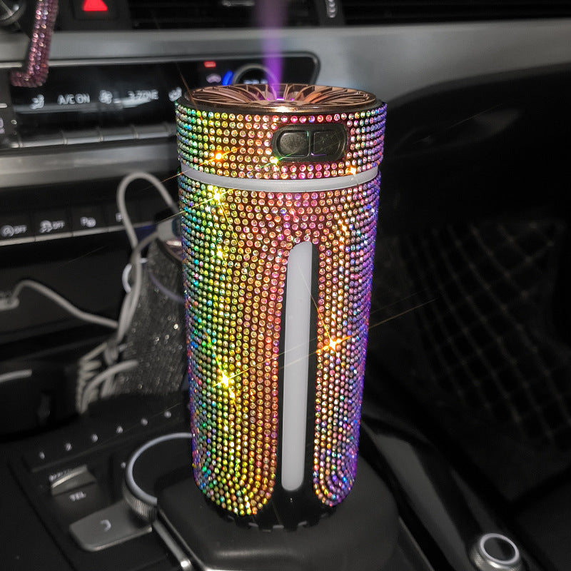 Sparkling rhinestone-covered portable humidifier emitting mist inside a car with black interior