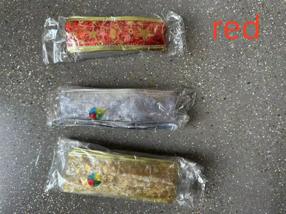 Three decorative metallic ribbon rolls in red, silver, and gold packaging on a speckled surface with red text 'red'