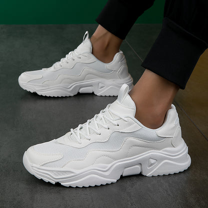 Person wearing stylish white chunky sneakers with mesh and leather details on grey floor
