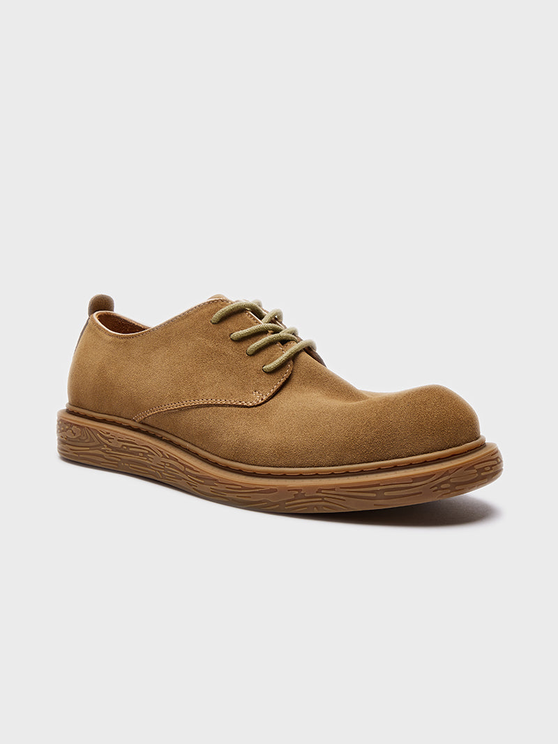 Brown suede casual shoe with textured sole and light green laces on white background