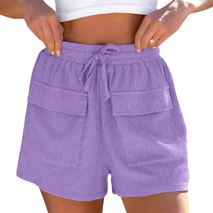 Woman wearing high-waisted lavender textured shorts with front flap pockets and drawstring waist