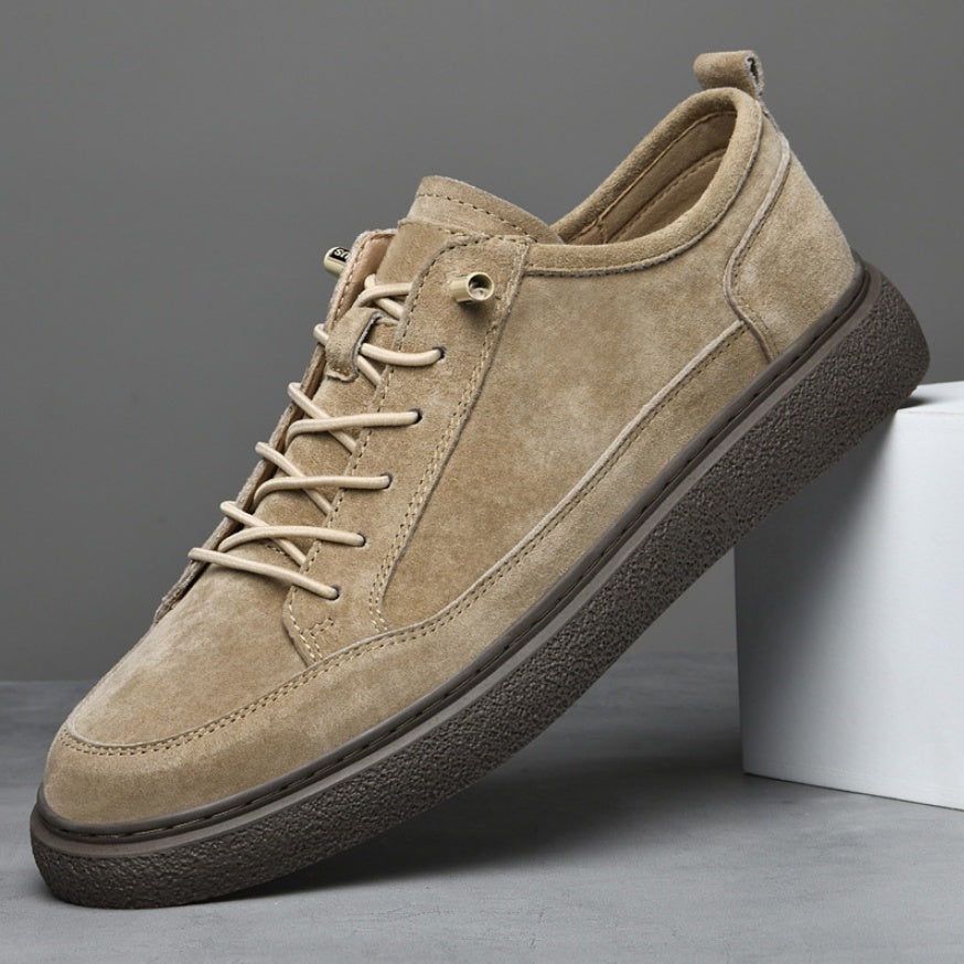 Beige suede men's casual sneaker with brown textured sole on gray background
