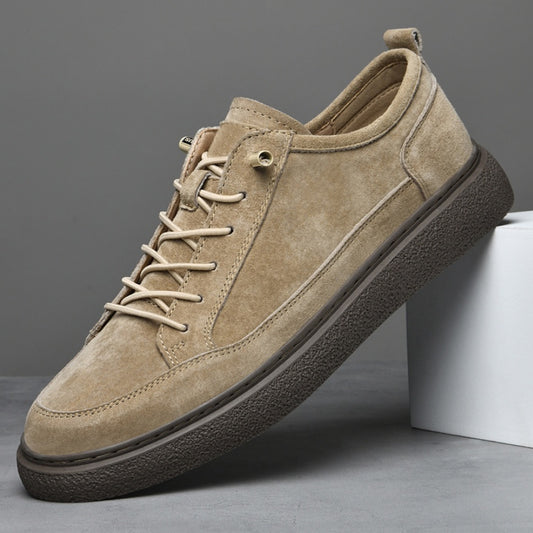 Beige suede men's casual sneaker with brown textured sole on gray background