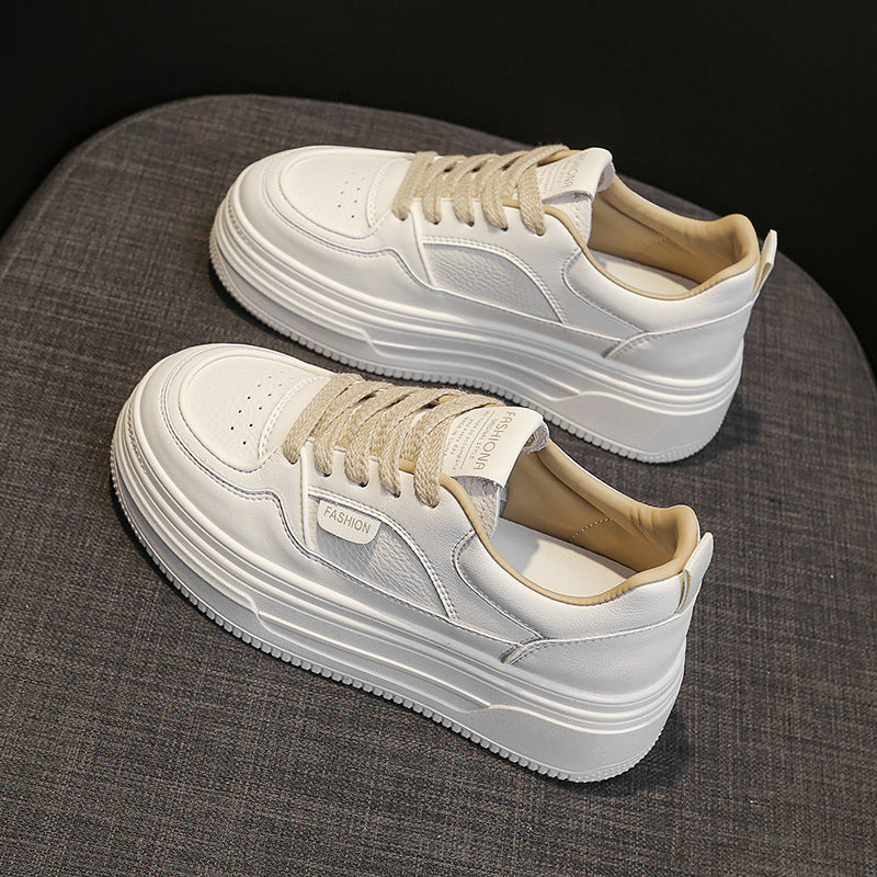 White platform sneakers with beige laces on gray fabric surface, featuring FASHION tag