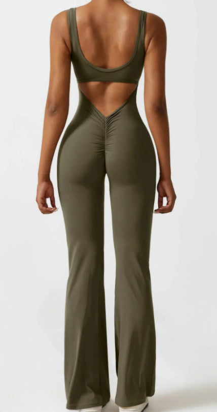 Back view of woman in olive green sleeveless cutout jumpsuit with flared legs and ruched detailing