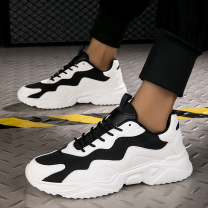 Black and white chunky sneakers on feet against metal floor with caution tape