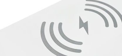Close-up of a white surface featuring a gray wireless charging symbol with concentric waves and a lightning bolt icon