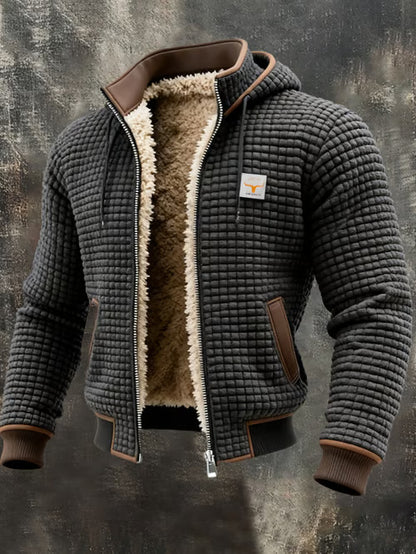 Men's quilted black jacket with sherpa lining, brown accents, and a front zipper on dark textured background