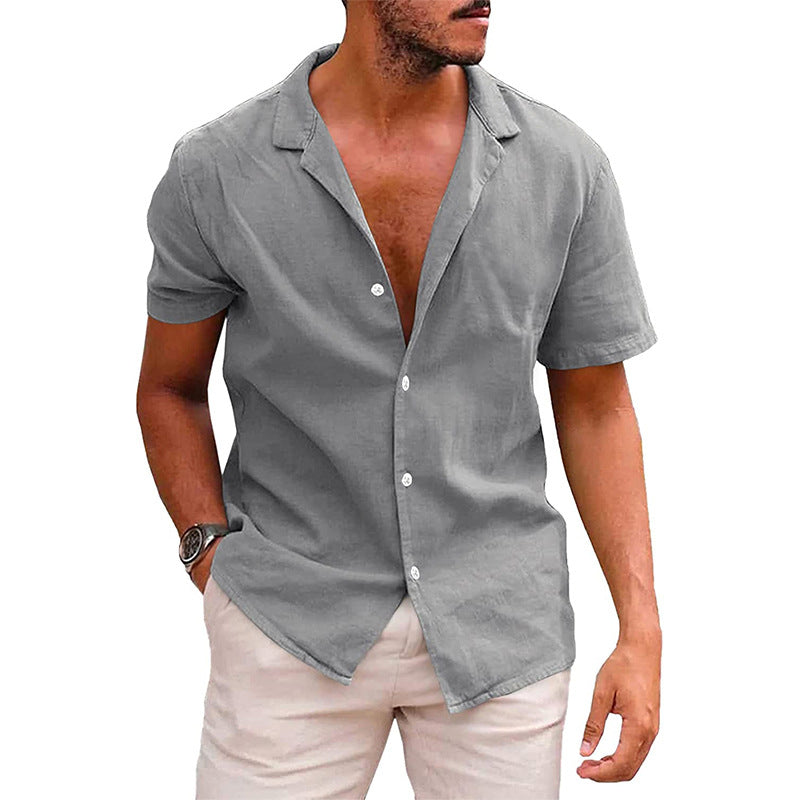 Man wearing casual grey short-sleeve button-up shirt with beige pants, hands in pockets