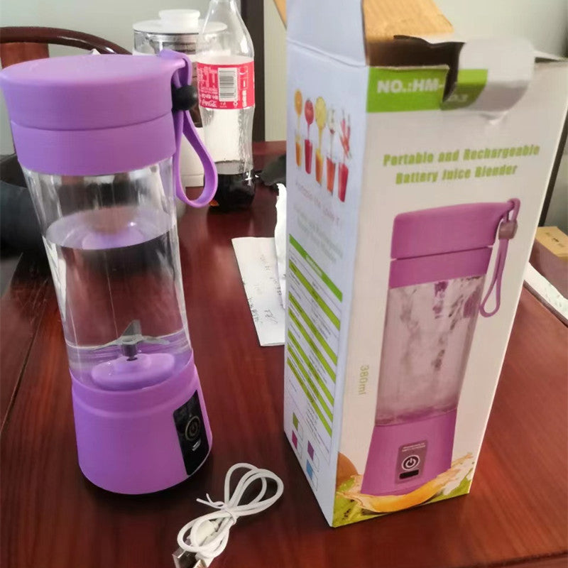 Portable rechargeable battery juice blender with purple base and lid, USB cable and packaging box on wooden table