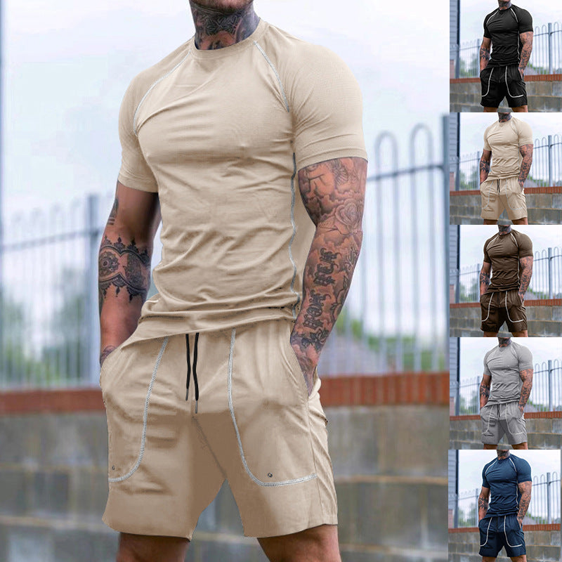 Man wearing beige muscle-fit casual t-shirt and shorts set with tattoos standing outdoors