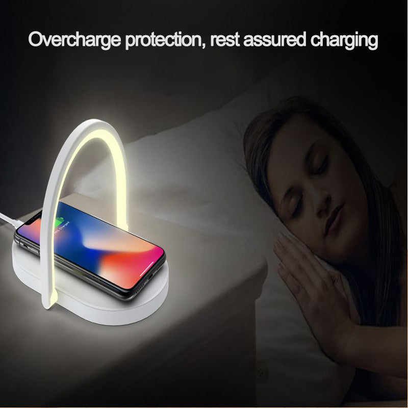 Wireless charger with glowing LED arch charging smartphone on nightstand next to sleeping woman
