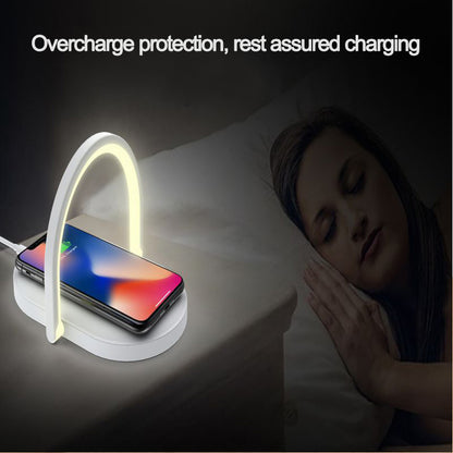 Wireless charger with glowing LED arch charging smartphone on nightstand next to sleeping woman