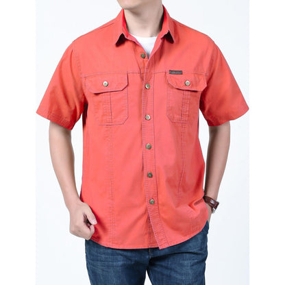 Man wearing a coral short-sleeve button-up shirt with chest pockets and jeans