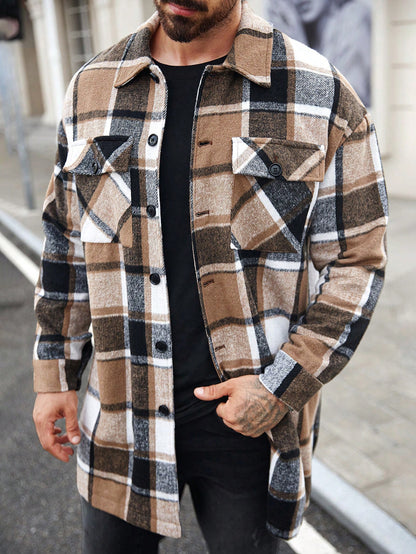 Man wearing brown, black, and white plaid button-up jacket over black shirt on city street
