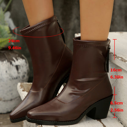 Brown leather ankle boots with 6.5cm heels and zipper detail, worn on wooden steps