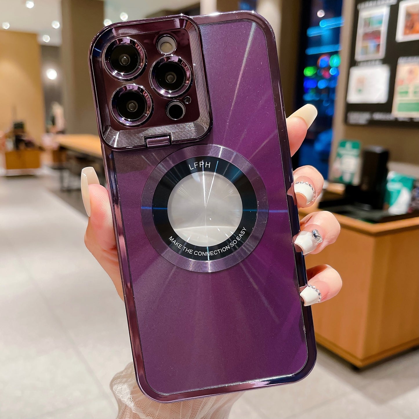 Hand holding purple iPhone with shiny camera lenses and circular magnetic ring on case