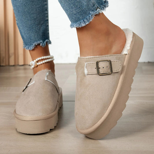 Beige suede slip-on platform slippers with buckle and faux fur lining worn with blue frayed jeans