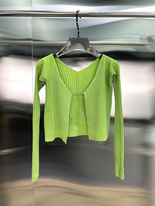 lime green ribbed knit long sleeve cardigan with silver hook closure hanging on metal rack