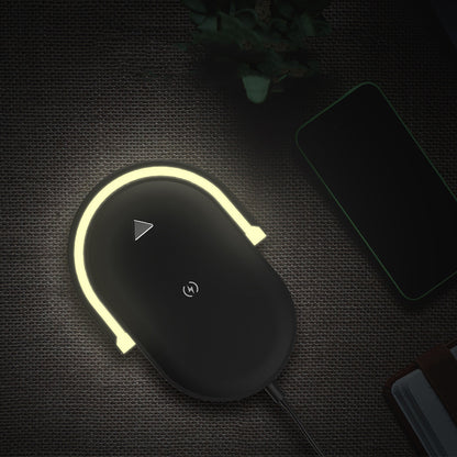 Wireless charging pad with glowing LED light on textured surface near smartphone and notebook