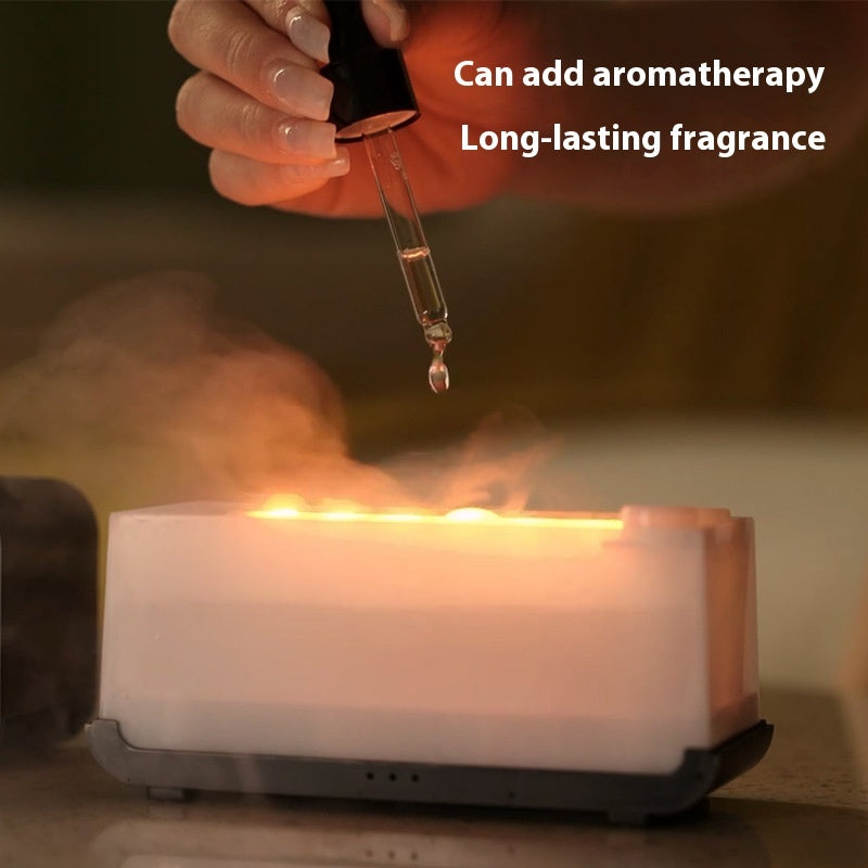 Hand adding essential oil drop into white aromatherapy diffuser emitting warm mist
