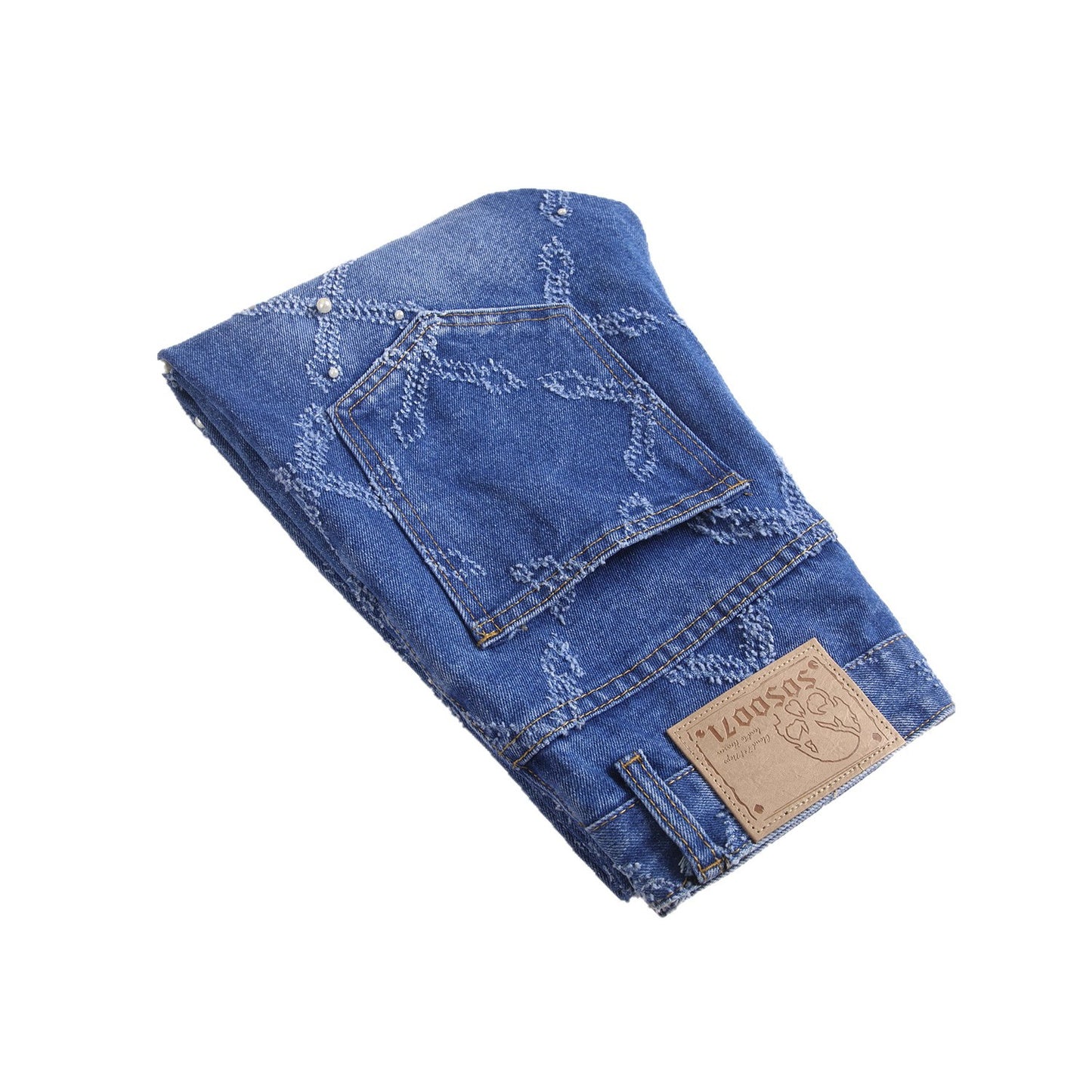 Folded blue denim jeans with embroidered cross patterns and leather brand patch