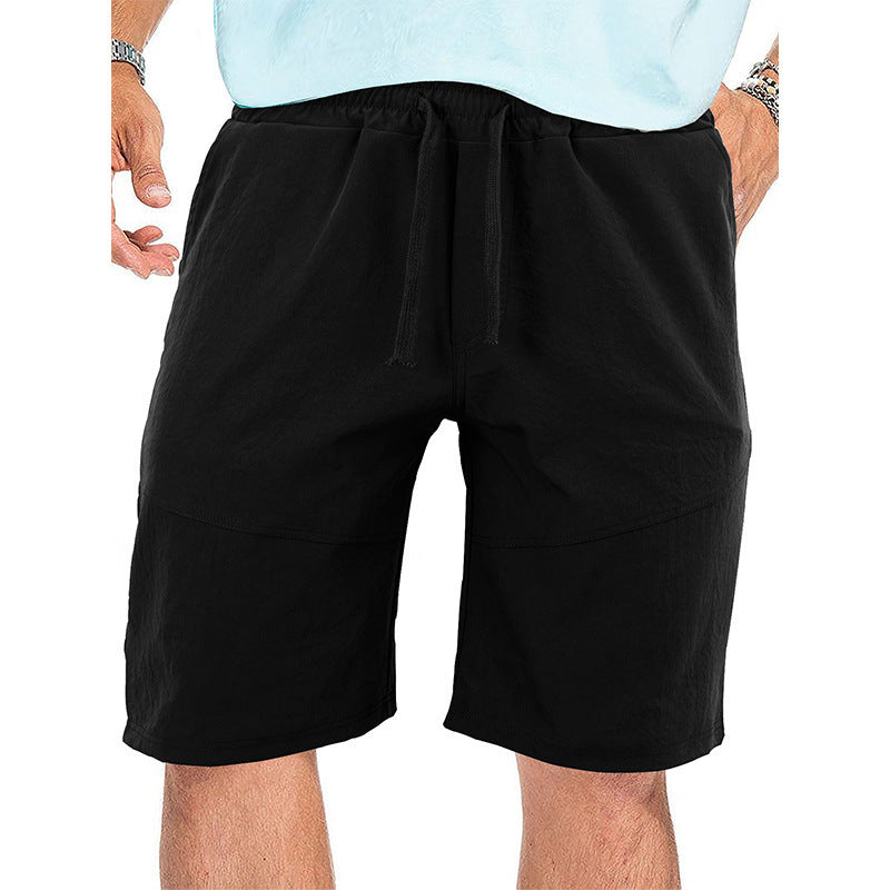 Men's black casual drawstring shorts with side pockets, worn with a light blue shirt