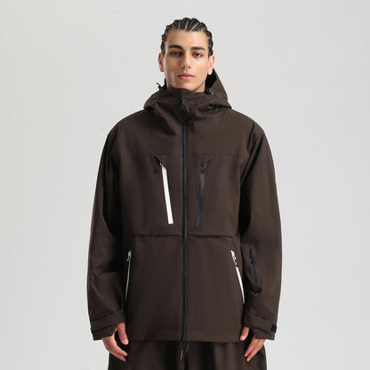 Young man wearing a dark brown zip-up hooded jacket with multiple zippered pockets on a gray background