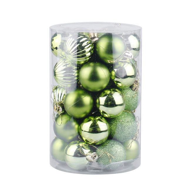 Clear plastic cylinder container filled with assorted green Christmas ornaments in matte, shiny, ribbed, and glitter finishes