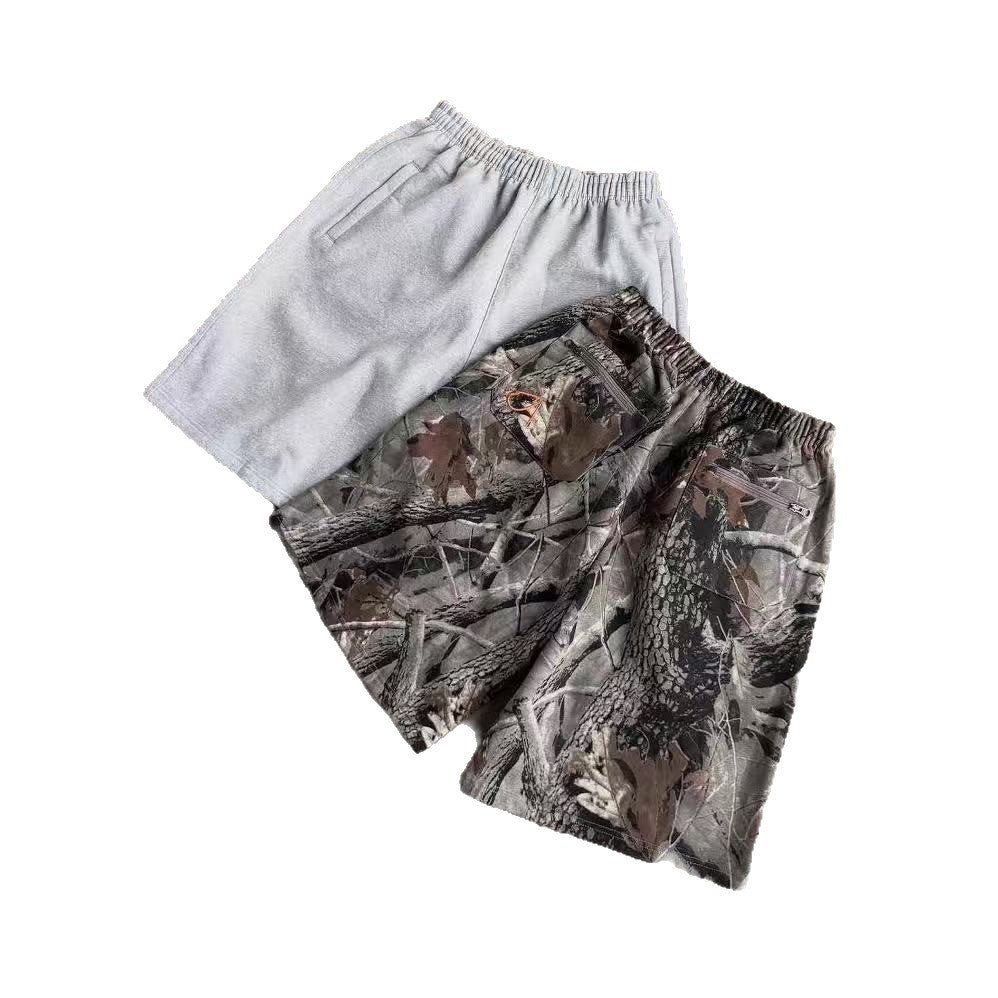 Two pairs of men's shorts, one solid gray and one camouflage print with zippers
