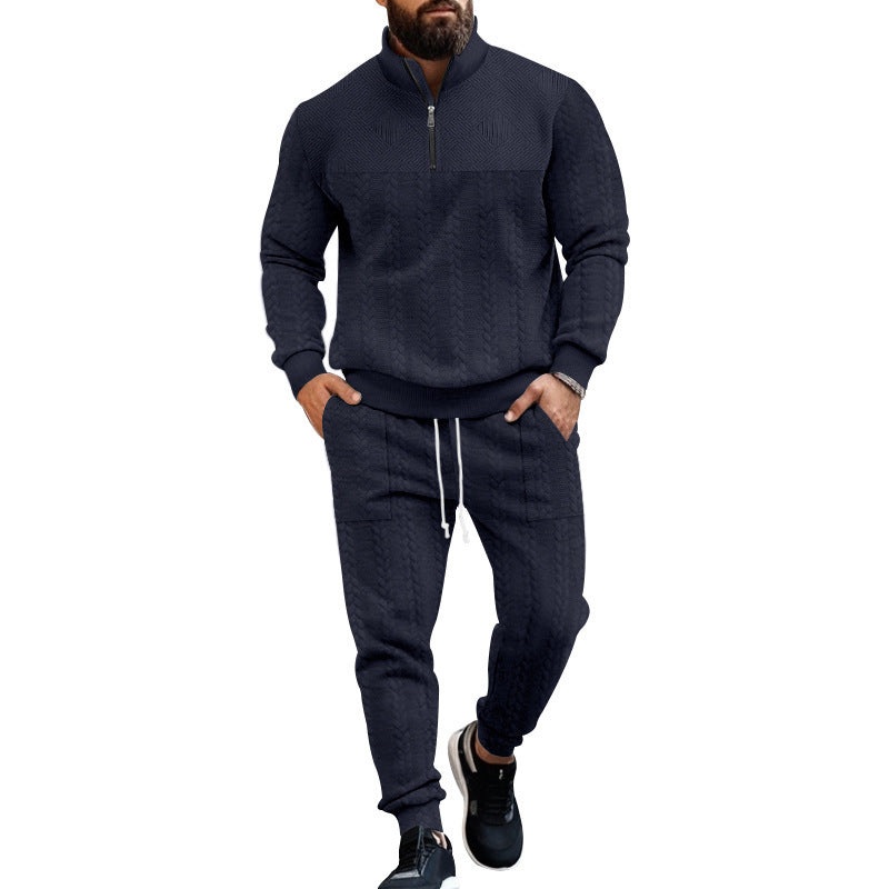 Man wearing navy blue cable knit quarter zip sweater and matching jogger pants with black sneakers
