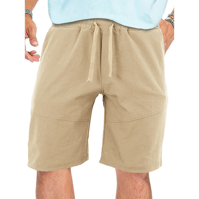Men's beige casual cotton drawstring shorts with elastic waist, styled with light blue shirt