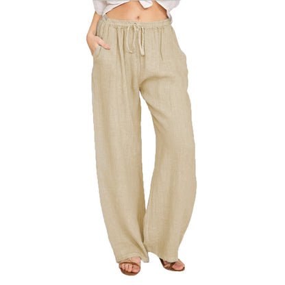 Woman wearing beige linen wide-leg pants with elastic waistband and drawstring, hands in pockets