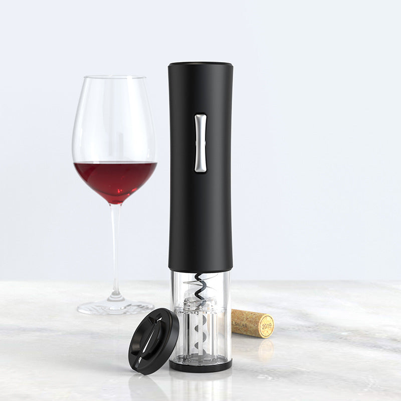 Electric wine opener with black handle, corkscrew, wine glass with red wine and cork on marble surface